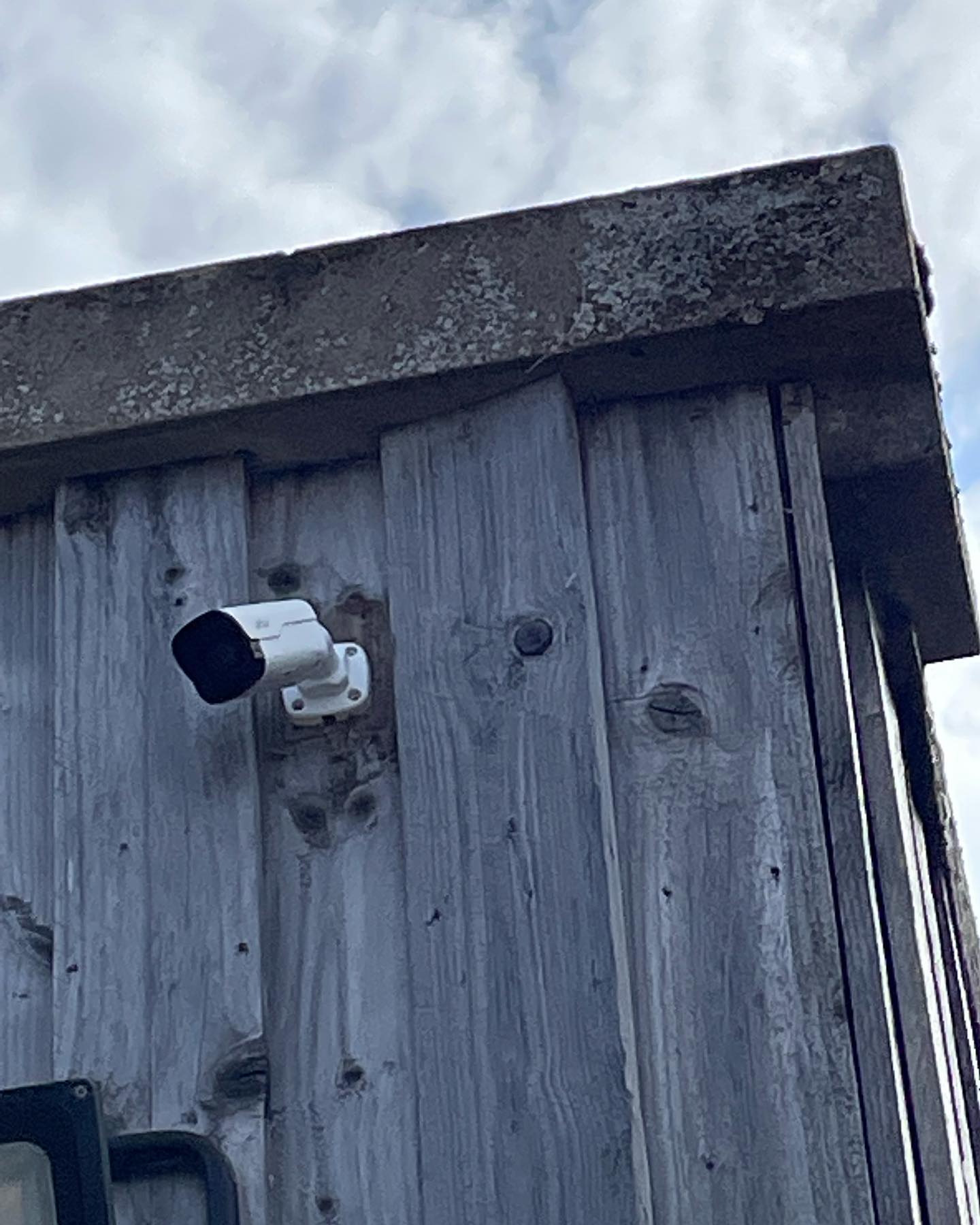 Bullet camera for CCTV systems fixed to weathered timber cladding