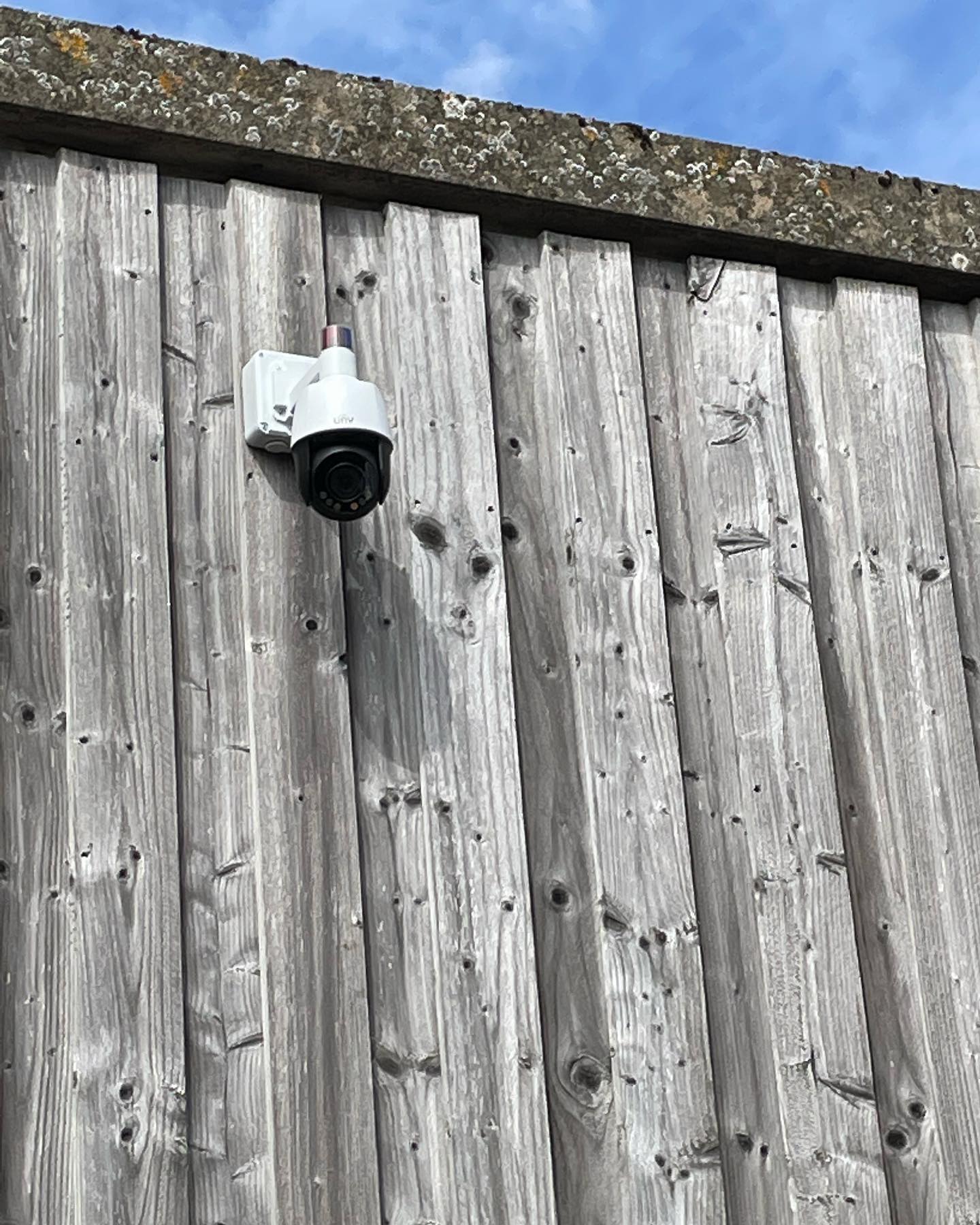CCTV systems for outbuildings: white security camera mounted on timber cladding