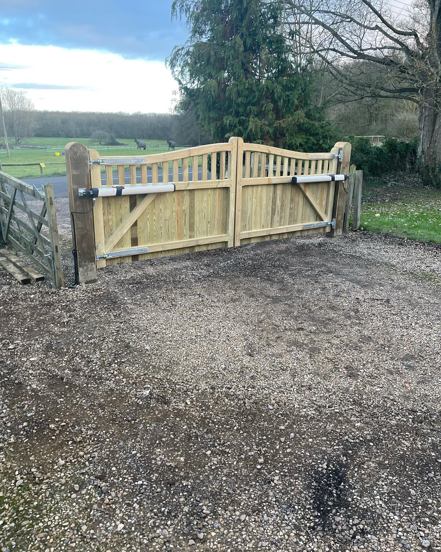 Timber farm gate and fencing beside a gravel driveway
