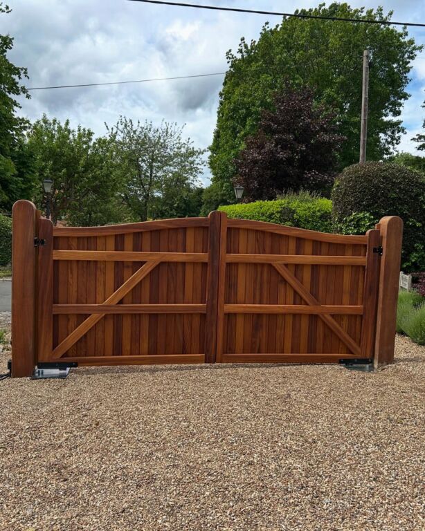 Rural security systems: rear view of double wooden security gates across a gravel driveway
