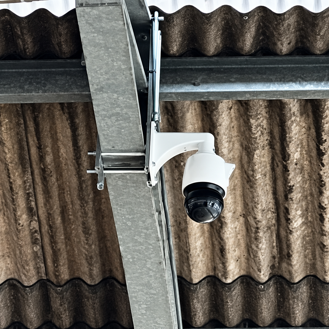 Farm CCTV systems: security camera mounted beneath a corrugated building roof